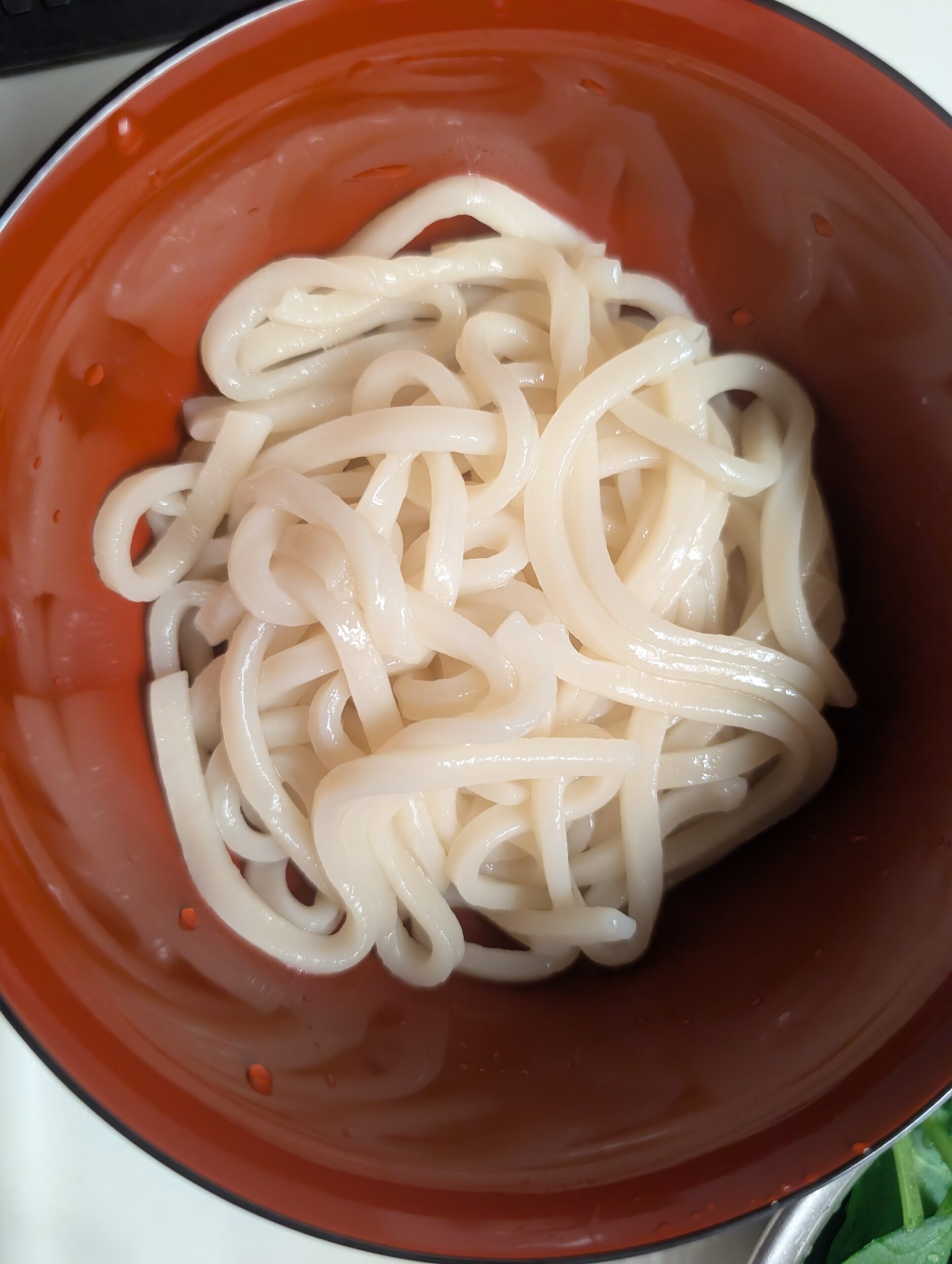 ゆでたつるとんたんのうどんを器によそった写真