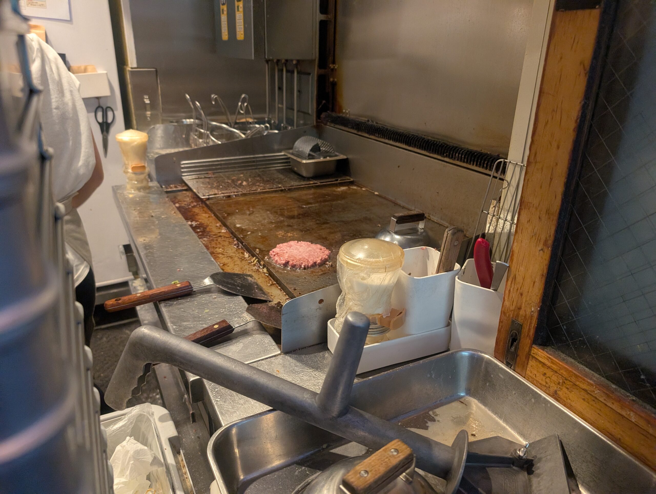 JB's BURGER代々木で鉄板にパテを置いてつぶしている様子